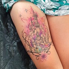 a woman's thigh with a castle tattoo on it