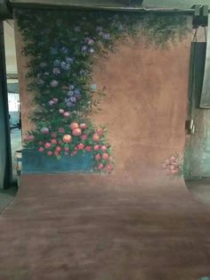 a room with flowers painted on the wall and carpeted flooring in front of it