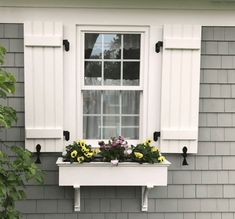 a window box with flowers in it on the side of a house