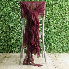 a chair with a red cloth draped over it in front of a green wall and wooden floor