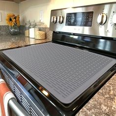 a stove top oven sitting inside of a kitchen next to a counter with flowers on it