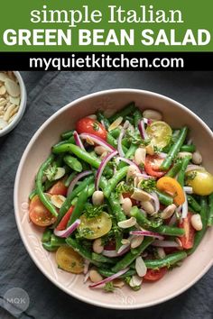 a bowl filled with green bean salad next to another bowl full of beans and tomatoes