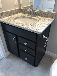 a bathroom vanity with marble top and drawers