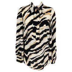 GUCCI long sleeve blouse comes in black and white animal print silk fabric with hidden placket and neck tie. Made in Italy.Excellent Pre-Owned Condition. Marked: 40 Measurements: Shoulder: 17 inches Bust: 40 inches Sleeve: 23 inches Length: 31 inches Reference: 117142 Category: Blouse More Details Brand: GUCCI Size: 4 Color: Beige Color 2: Black & White Fabric: Silk Pattern: Print Style: Hidden Placket Age Group: Adult Gender: Female The House Of Gucci, Printed Silk Fabric, Black And White Top, Black And White Fabric, Black And White Tops, Fitted Trousers, Printed Silk, White Silk, Silk Top