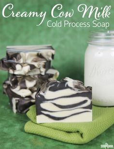 a soap bar sitting on top of a green towel next to a jar of milk