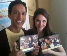 a man and woman holding up two dvd's