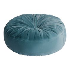 a blue round pillow sitting on top of a white floor