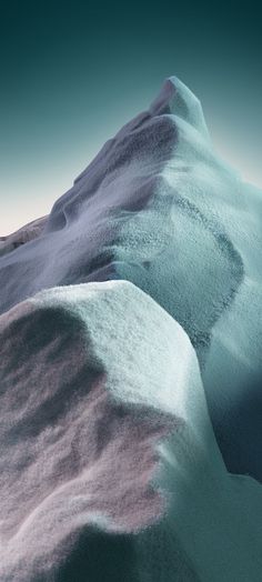 a mountain covered in snow next to a blue sky