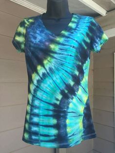 a blue and green tie - dyed shirt on a mannequin stand outside the house