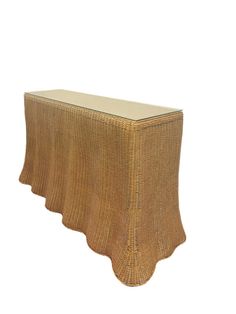 a wicker table with a glass top on it's legs and scalloped edges