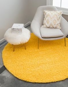 a chair and ottoman in a room with a yellow rug on the floor next to a window