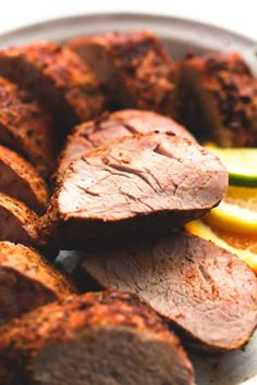 sliced meat and slices of lemon on a plate