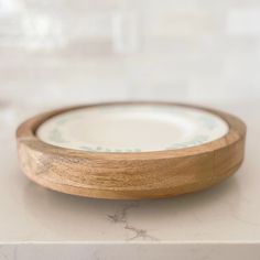 a wooden plate sitting on top of a white counter