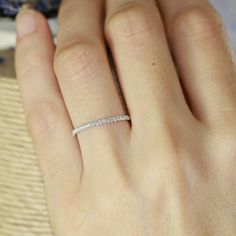 a woman's hand with a diamond ring on it