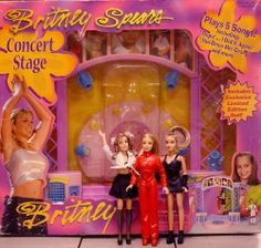 three dolls are posed in front of a pink and yellow box for a concert stage