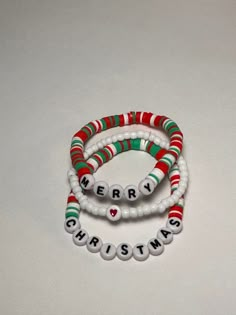 three beaded bracelets with the words merry christmas written in white and green beads