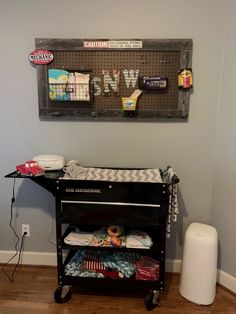 a baby crib is next to a wall with some items on it and a sign that says welcome