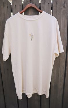 -Comfort Colors tee -Cream colored shirt -HAND embroidered (no machine) -Bouquet of wildflowers -SUPER SOFT shirt, great quality Our embroidered shirts are made with intention. Each shirt takes on average an hour to embroider, and we make them to order just for you - it's more personal that way. Each design has its own meaning. We take on a biblical meaning with our wildflowers. Wildflowers bloom where they are planted and they do it beautifully - God planted where you are for a reason, you can Styling Outfits, Wildflower Shirt, Blue Pendant Necklace, Embroidered Shirts, Lava Bead Bracelet, Wildflower Bouquet, Embroidered Tee, Embroidered Crewneck, Blue Pendant