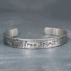 If you are a free spirited kind of gal, this is your bracelet. Each bracelet is individually made, so yours will be as unique as you are. Details Made from solid sterling silver Stamped with the words "Free Spirit". A lucky horseshoe is on the inside, because extra luck is always good. Other symbols: peace symbol, feather, flowers, etc,. Sizing The bracelet can be made in a size Small, Medium (fits most) and Large. Handmade Inspirational Silver Bracelets, Handmade Inspirational Silver Bracelet, Bohemian Hand Stamped Bracelets As Gift, Bohemian Silver Hand Stamped Bracelets, Bohemian Hand Stamped Bracelets For Gifts, Bohemian Hand Stamped Bracelets For Gift, Bohemian Silver Personalized Bracelets, Spiritual Stamped Sterling Silver Bracelets, Bohemian Stamped Cuff Bracelet For Gift