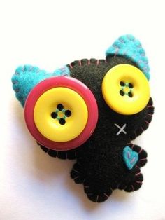 a black cat with yellow and blue buttons on it