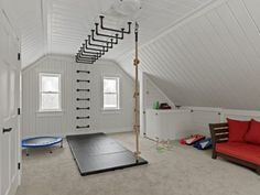 a room with white walls and an attic style ceiling has a yoga mat on the floor