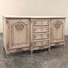 an old dresser is painted white and has ornate carvings on the doors, drawers, and sides