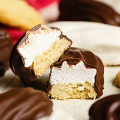 two pieces of chocolate covered cake with white frosting and one piece cut in half