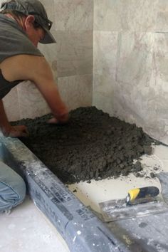 a man working on cement in a bathroom