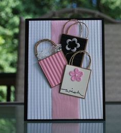 a close up of a card with two bags on it and a flower in the middle