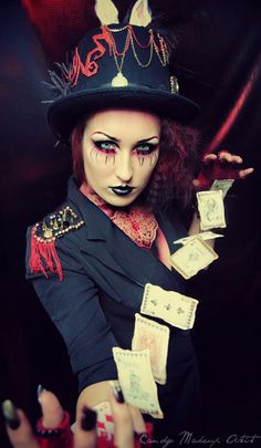 a woman dressed in black and red with makeup on her face, holding money up to the camera