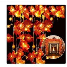 orange flowers are hanging from the ceiling with lights on them and in front of a black background