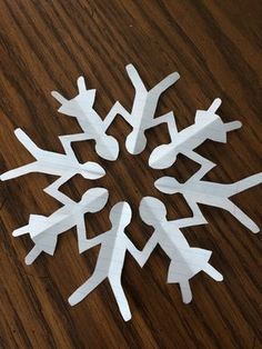 white snowflakes are arranged on a wooden table