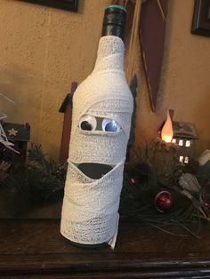 a bottle wrapped in paper with eyes and nose