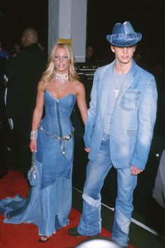 the man and woman are dressed up in blue outfits, one is wearing a cowboy hat