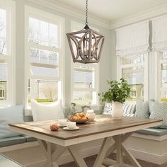 a dining room table that has some fruit on it and two windows in the background