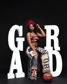 a woman sitting on top of a basketball next to the letters grad and blac