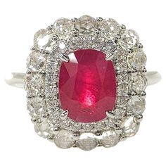 Step into the world of glamour and sophistication with this exquisite double halo ring featuring a stunning IGI Certified 2.26 Carat ruby in a deep purplish-red color, elegantly cut into a rectangular cushion shape. The intense hue of the ruby exudes passion and allure, captivating the eye with its rich and luxurious tones. Nestled within a sparkling embrace of natural diamonds, the ruby takes center stage, radiating a mesmerizing beauty that commands attention. Crafted in 18K white gold, the setting of this ring showcases a double halo design adorned with a total of 38 round brilliant and round rose cut diamonds, weighing 0.88 carats in total. The intricate details of the rose cut diamonds in the outer halo add a touch of antique charm, giving the ring a unique and special character that Luxury Oval Ruby Ring In Art Deco Style, Ruby Diamond Rings, Ruby Diamond, Ruby Ring, Halo Rings, Rose Cut Diamond, Cocktail Rings, Rose Cut, Halo