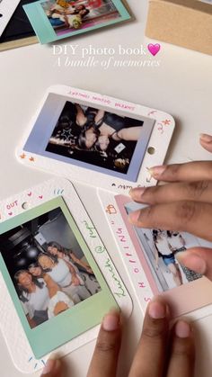 two hands are holding polaroid frames with pictures on them and the other hand is pointing at it