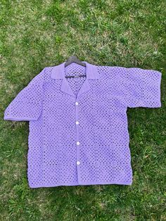 a purple shirt laying on the grass