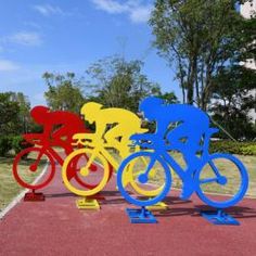 three different colored bikes are on display in the middle of a red, yellow and blue area