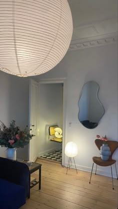 a living room filled with furniture and a round light fixture