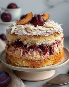 a close up of a cake on a plate with cherries and almonds in the background