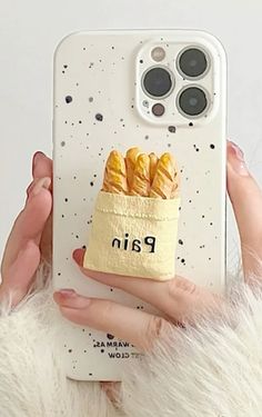 a person holding up a cell phone case with bread in it