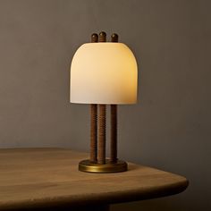 a table lamp sitting on top of a wooden table next to a white light bulb