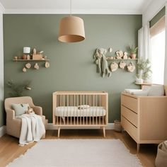 a baby's room with green walls and wooden furniture