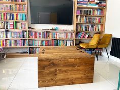 a living room with bookshelves and a television on the wall in front of it