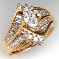 a gold ring with two rows of baguettes and an oval cut diamond on the side