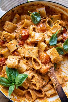 a skillet filled with pasta and spinach