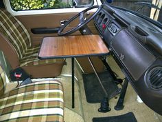 the interior of a car with a wooden table and steering wheel attached to it's center console