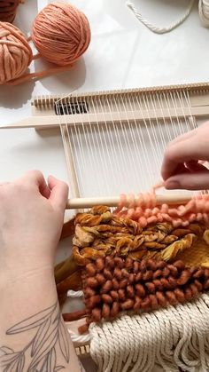 two hands are working on a weaving project